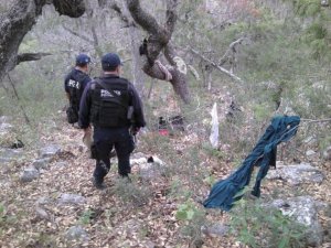 Policía investigan la zona del accidente donde los restos quedaron esparcidos en un amplia área.