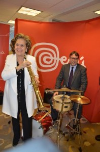 La embajadora peruana María Teresa Merino de Hart, Cónsul del Perú en Nueva York, ensaya con un saxo mientras que el Agregado Comercial del Perú en Nueva York, Conrado Falco lo hace con una batería, durante el reciente anuncio de la actividad artística. 